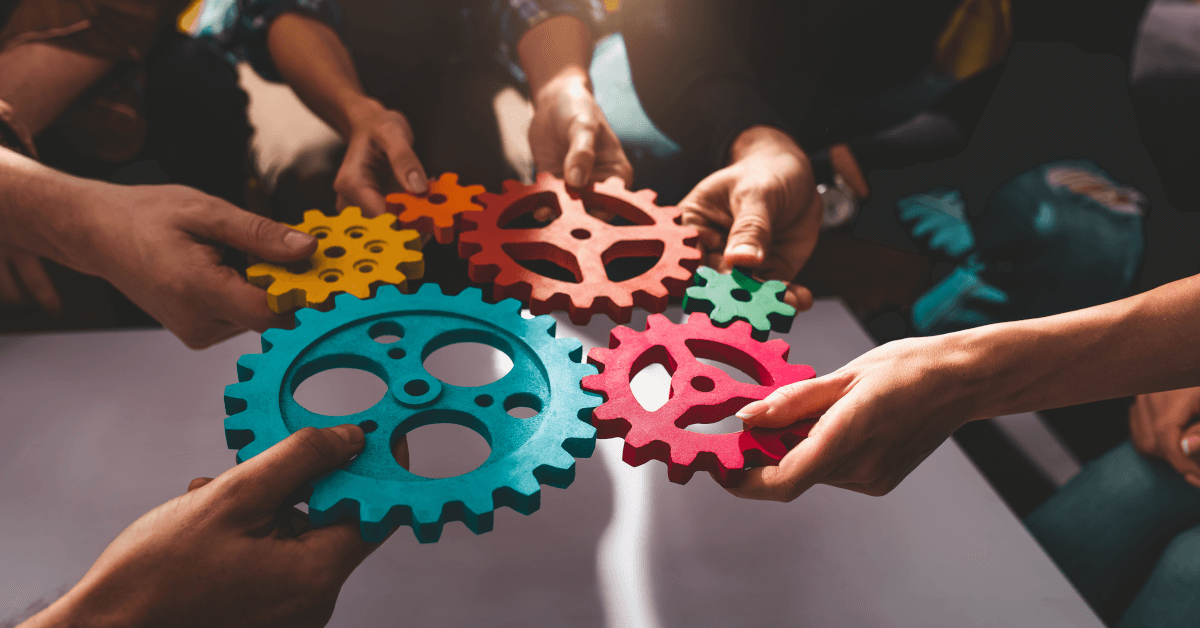 People fitting colored gears together.