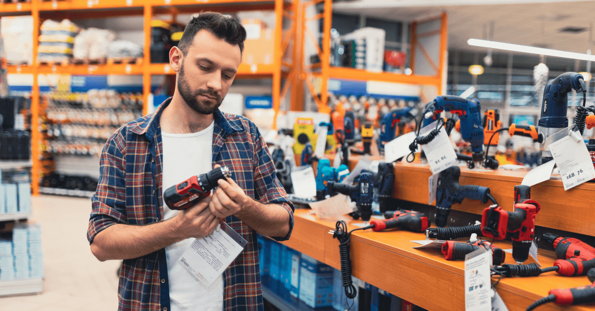 A man choosing a tool at a hardware store.