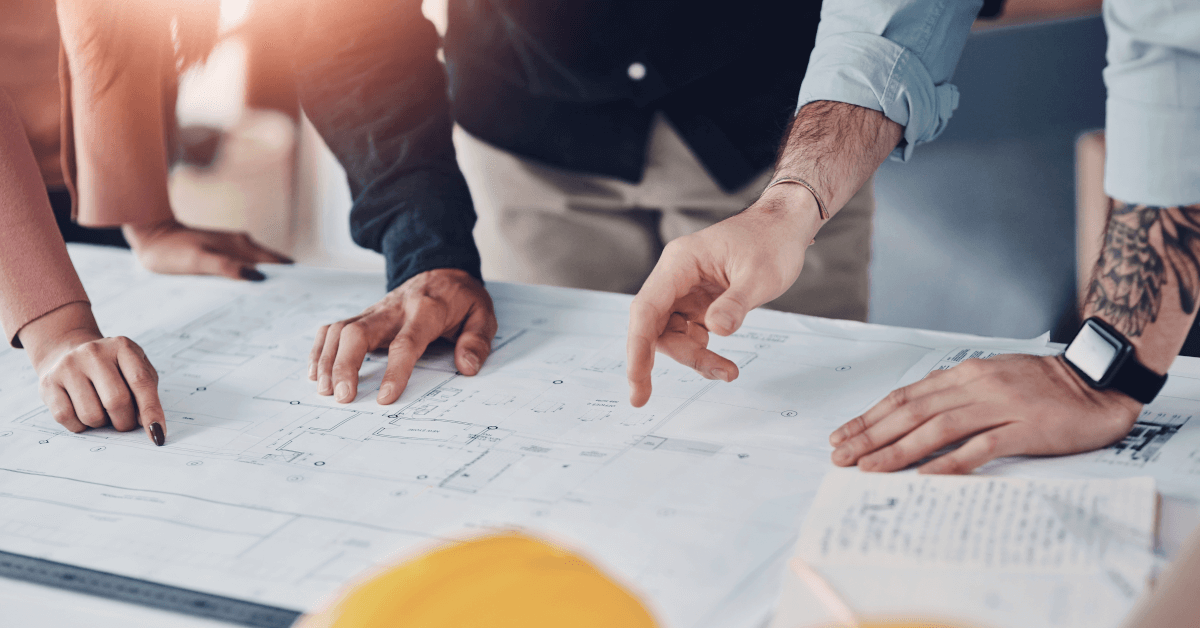 Several people working around a table on a detailed plan.