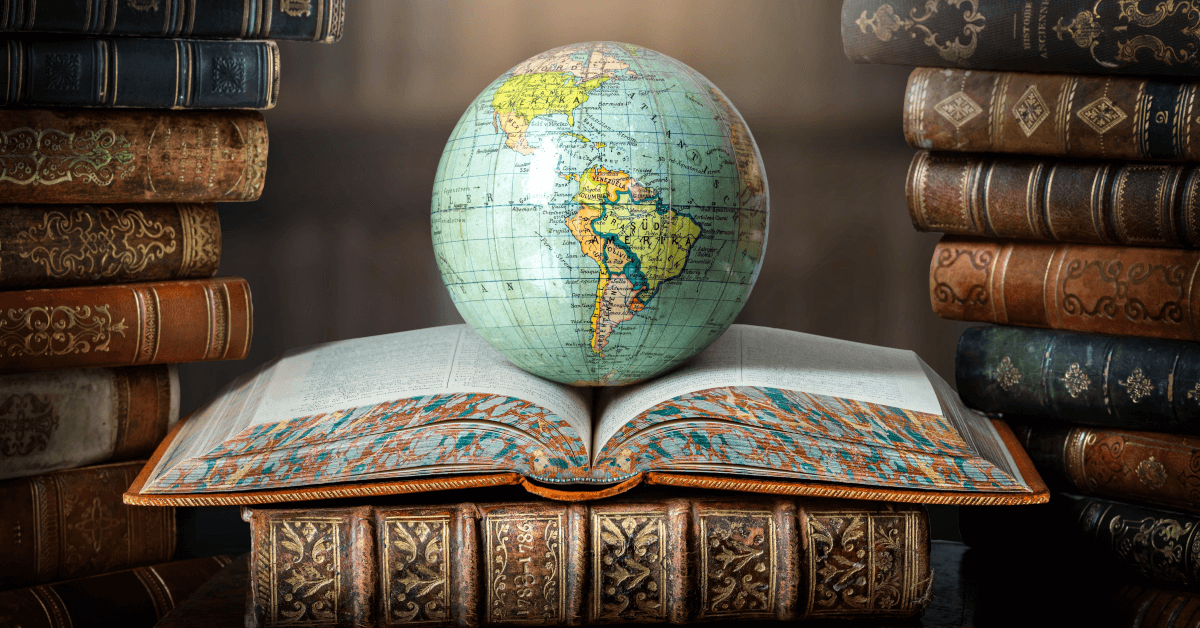 An open book in a library, with a globe on top of it.